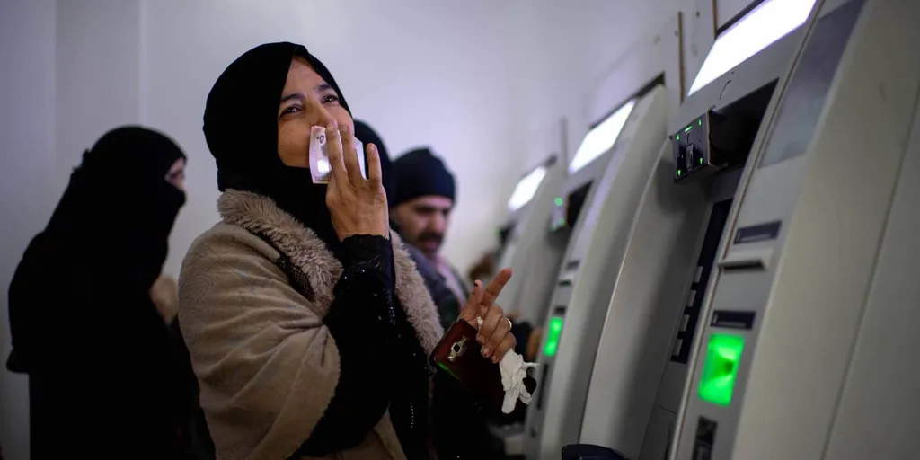 Woman receives monthly payment through UNHCR's cash assistance program