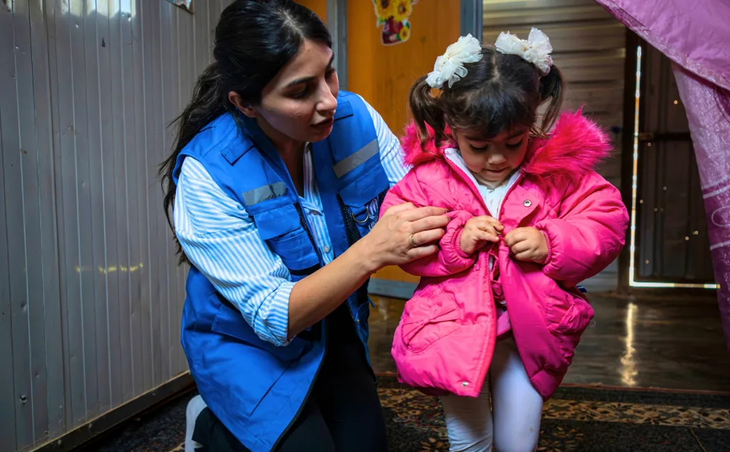 Jordan. Miral, 3, proudly shows her pink winter jacket inside her shelter in Zaatari refugee camp.